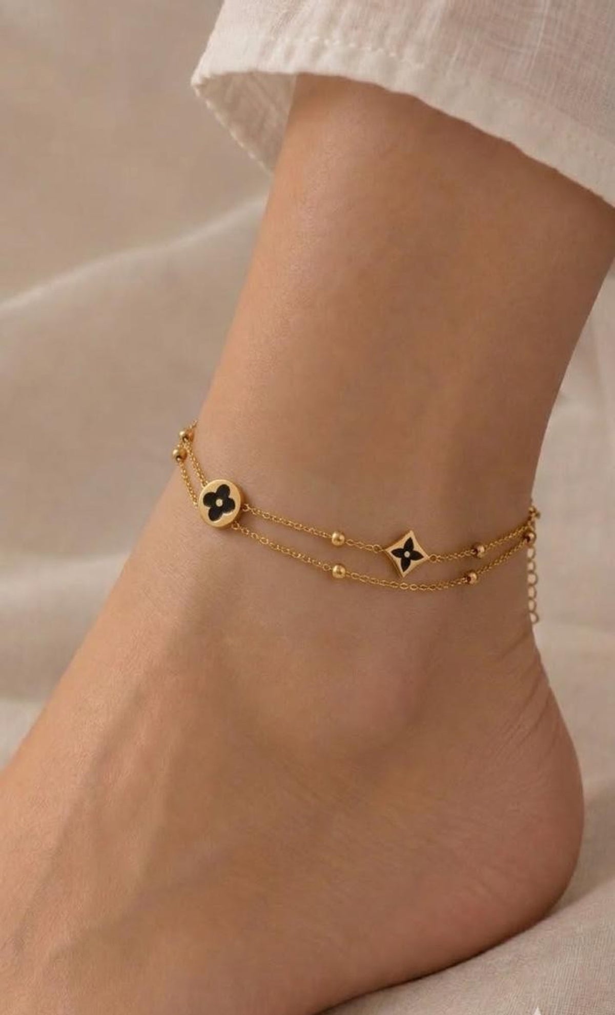 Double-strand gold-tone anklet with black enamel clover and star charms