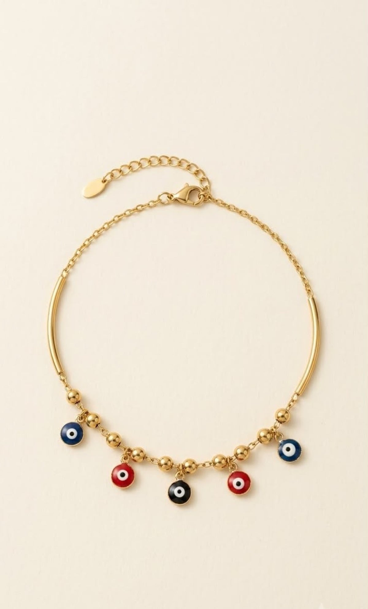 Pair of gold-tone anklets with curved bars and blue, red and black evil eye drops - view 2