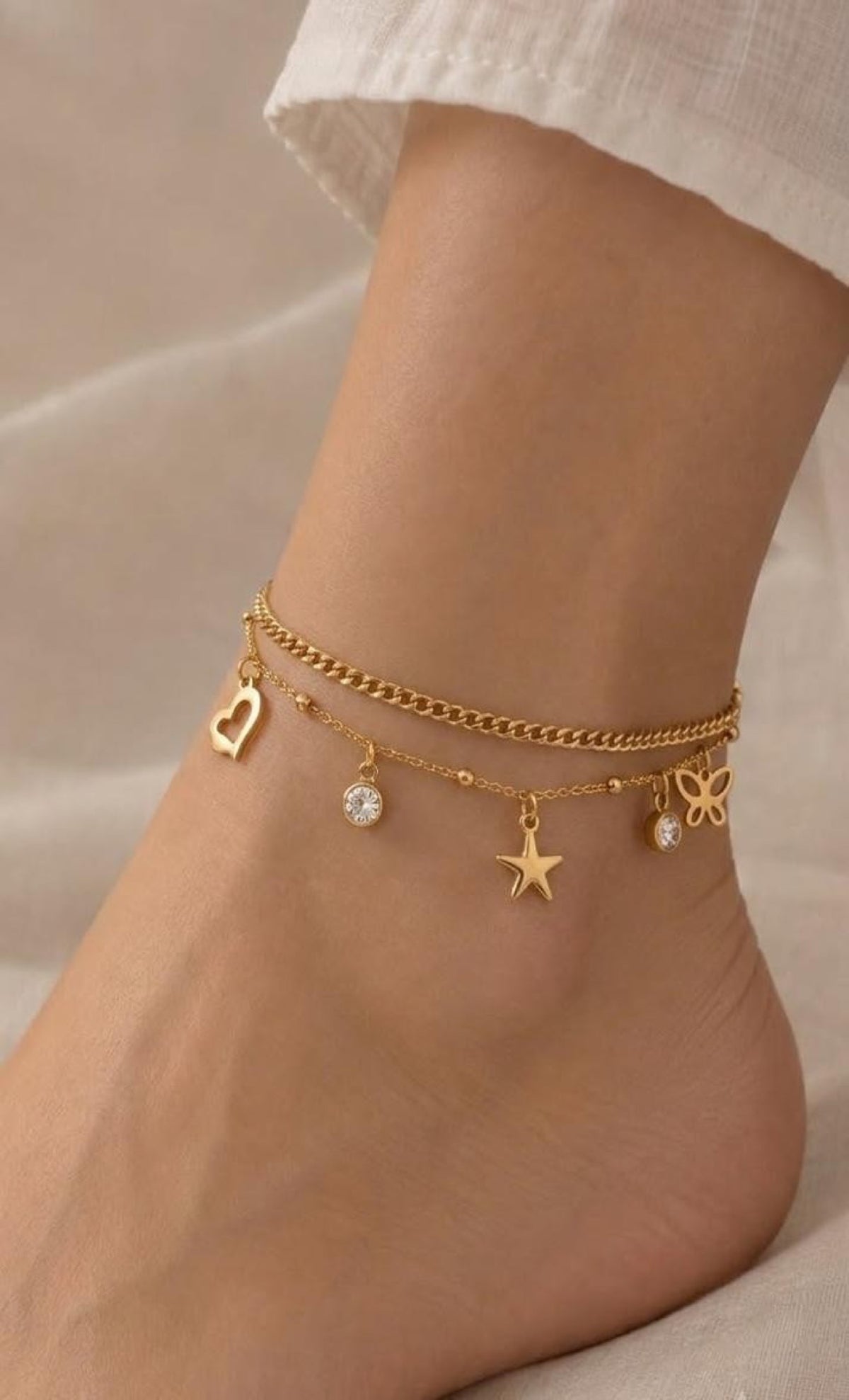 Gold-tone layered anklet with heart, star, butterfly and crystal charms