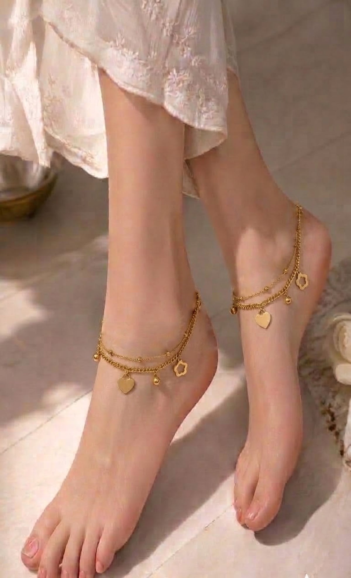 Pair of layered gold-tone anklets with heart, flower and peace charms
