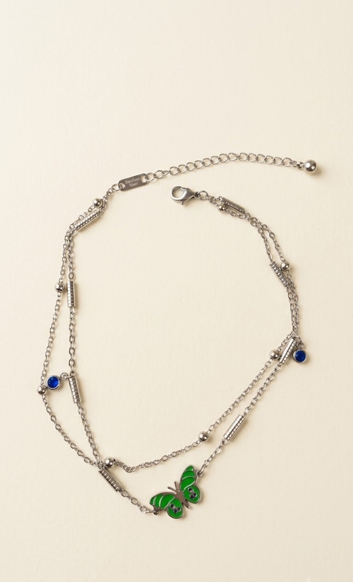 Pair of silver-tone layered anklets with green enamel butterfly and blue stones - view 2