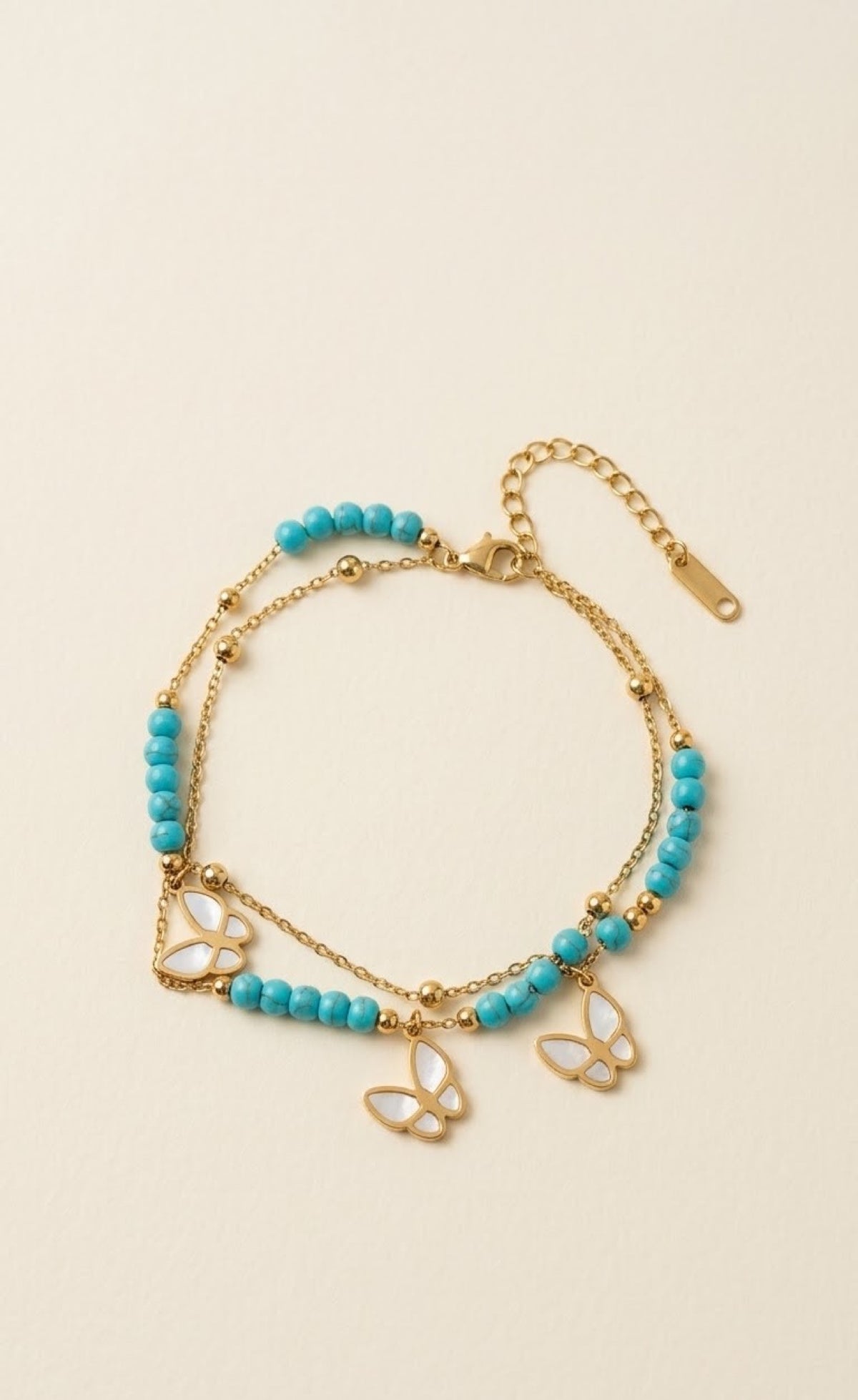 Gold-tone layered anklet with turquoise beads and white butterfly charms - view 2