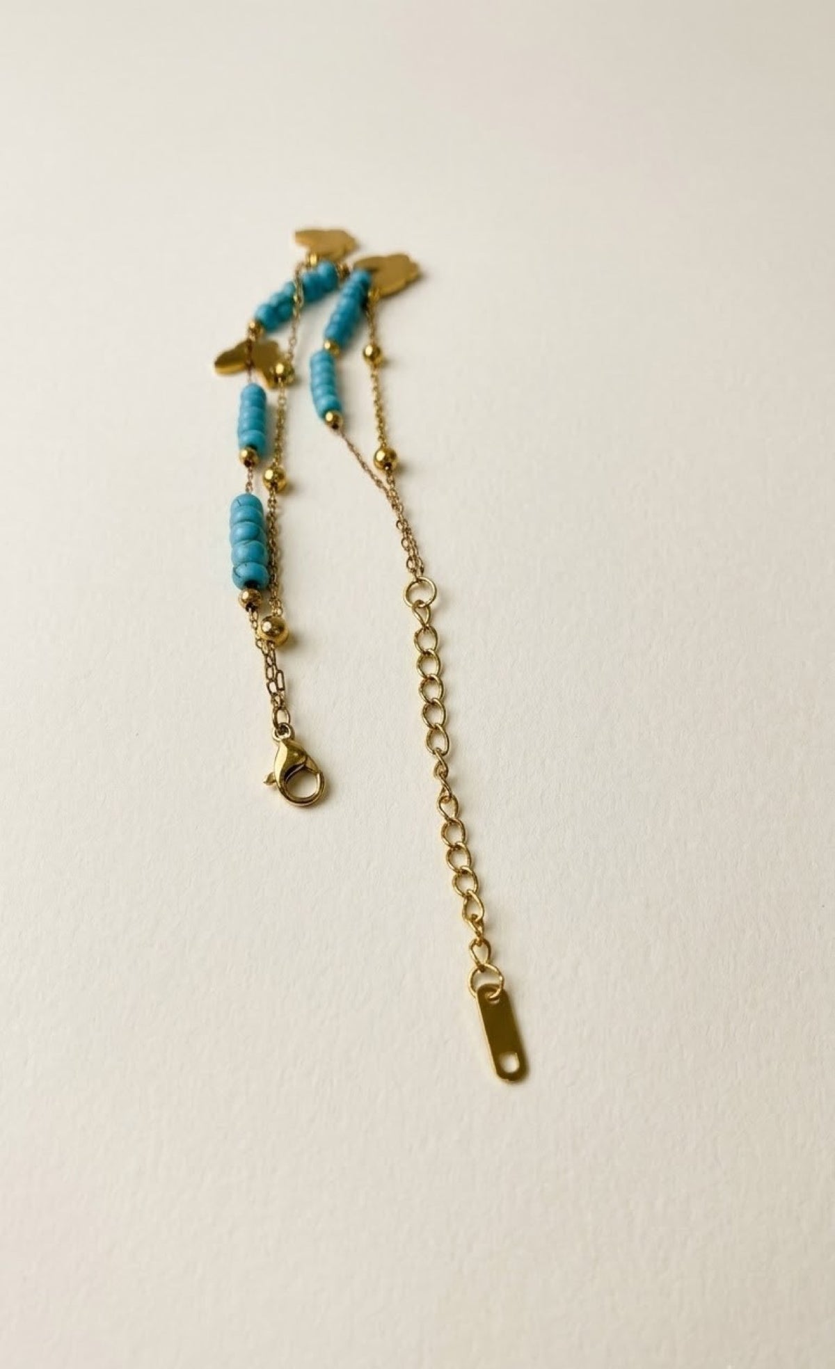 Gold-tone layered anklet with turquoise beads and white butterfly charms - view 3