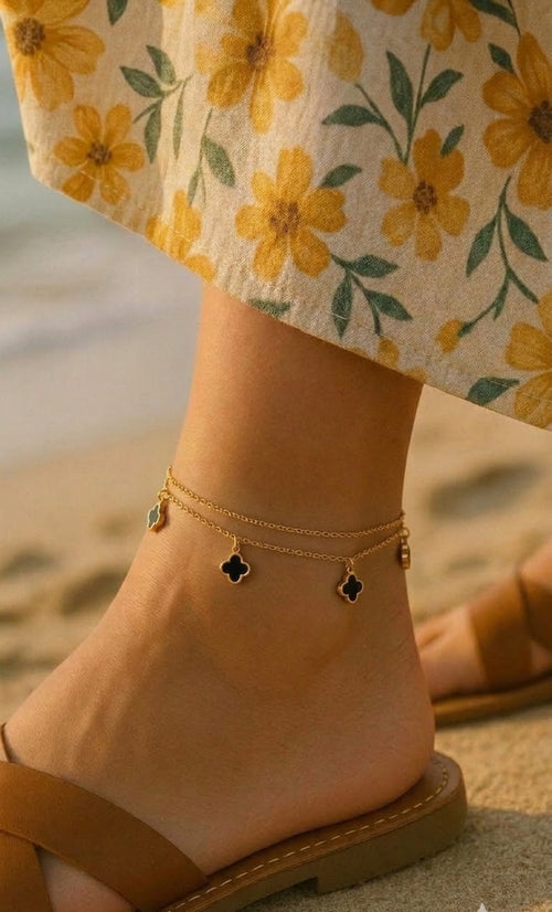 Gold-tone double-chain anklet with black four-leaf clover charms