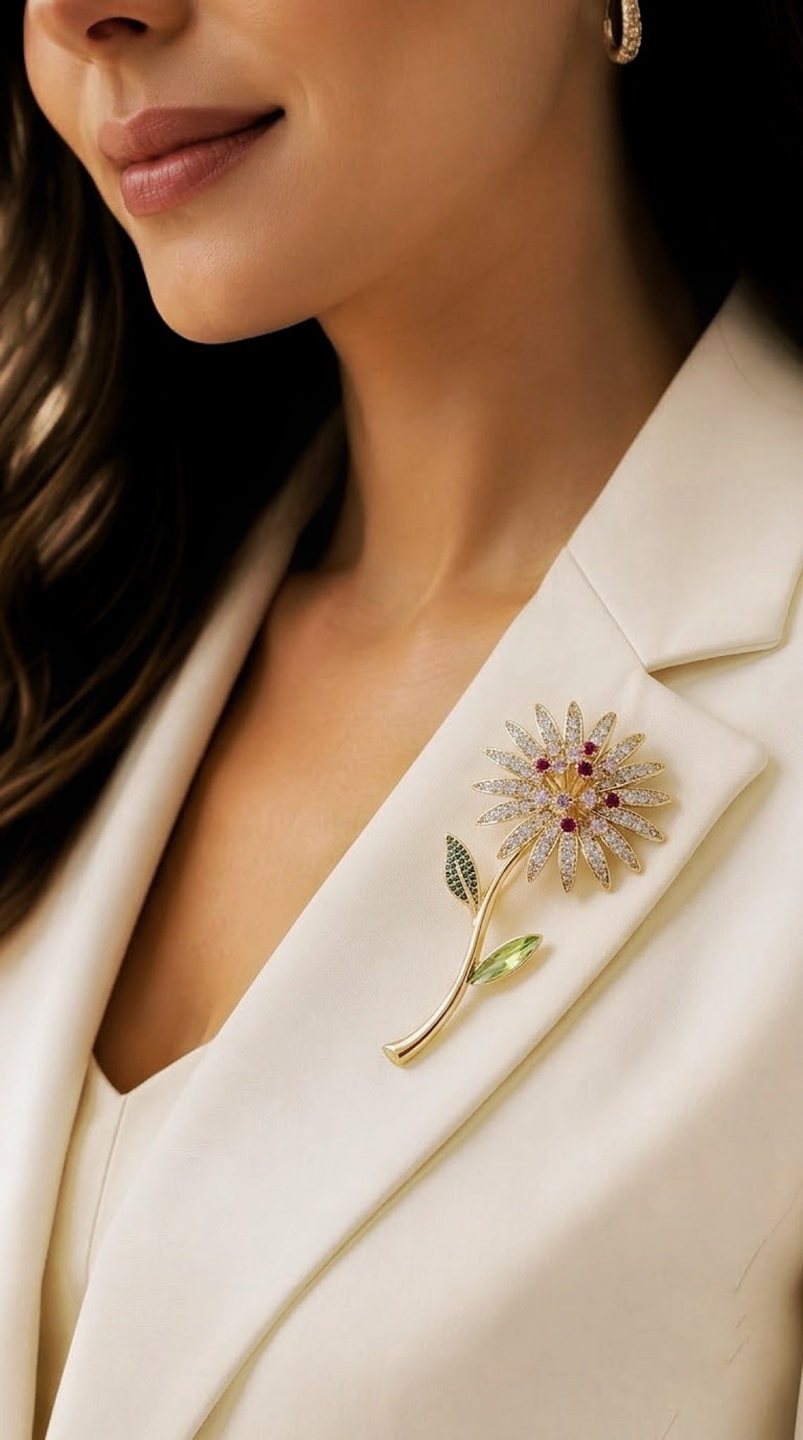 Gold-tone daisy stem brooch with clear crystal petals, red centre and green leaves