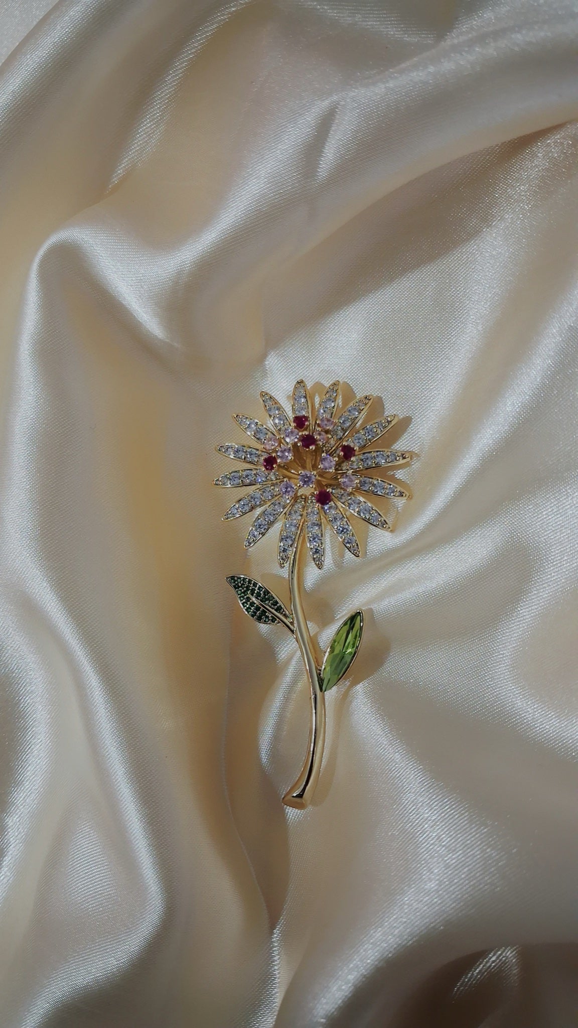 Gold-tone daisy stem brooch with clear crystal petals, red centre and green leaves - view 2