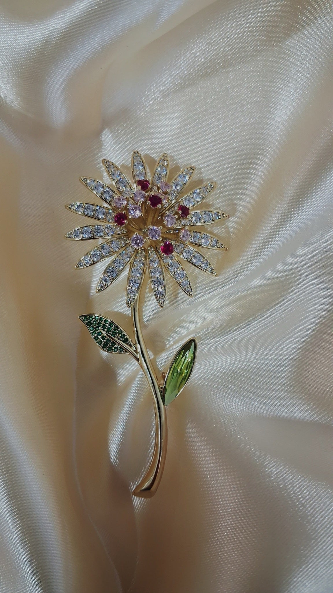 Gold-tone daisy stem brooch with clear crystal petals, red centre and green leaves - view 3