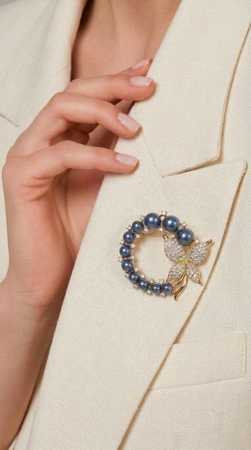 Gold-tone wreath brooch with blue faux pearls and crystal butterfly