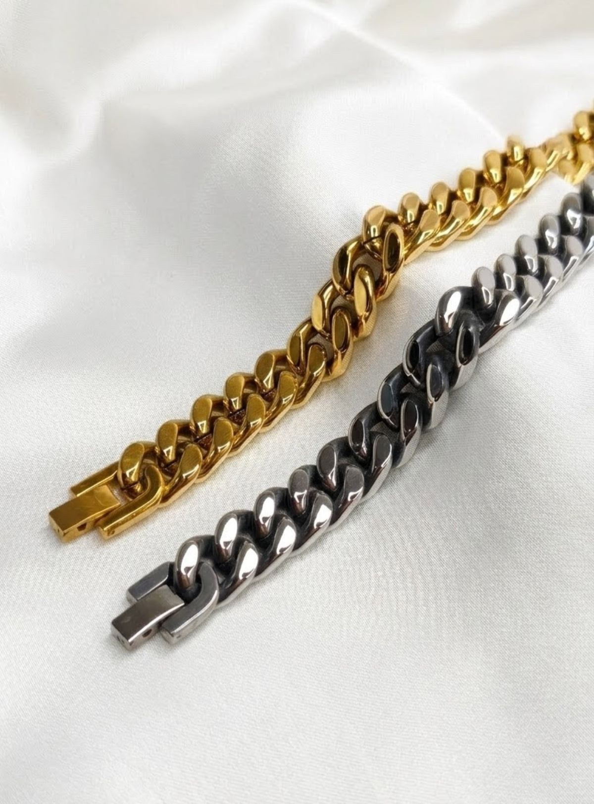 Classic curb fold-over bracelet in gold-tone and antiqued silver-tone on white satin