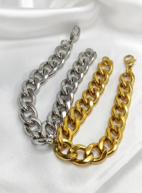 Chunky high-polish Cuban curb link bracelet with lobster clasp on white satin