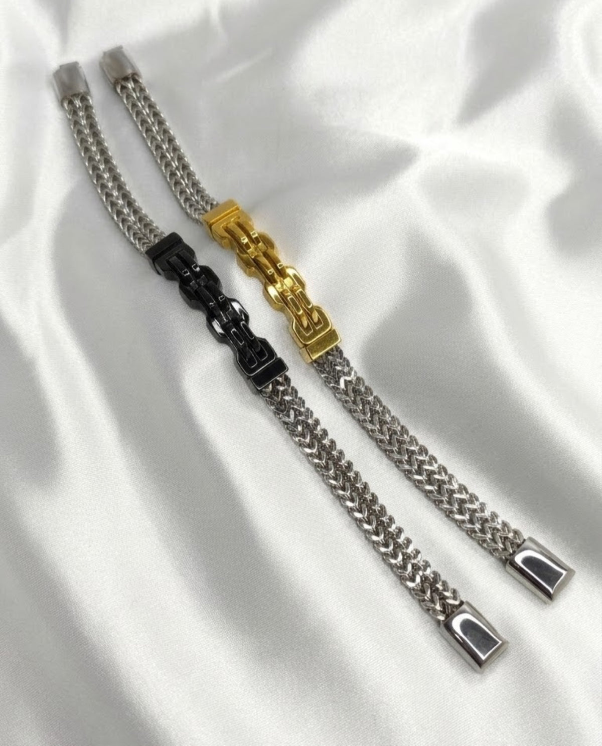 Silver-tone wheat chain bracelet with sculpted buckle-link centrepiece and polished end caps