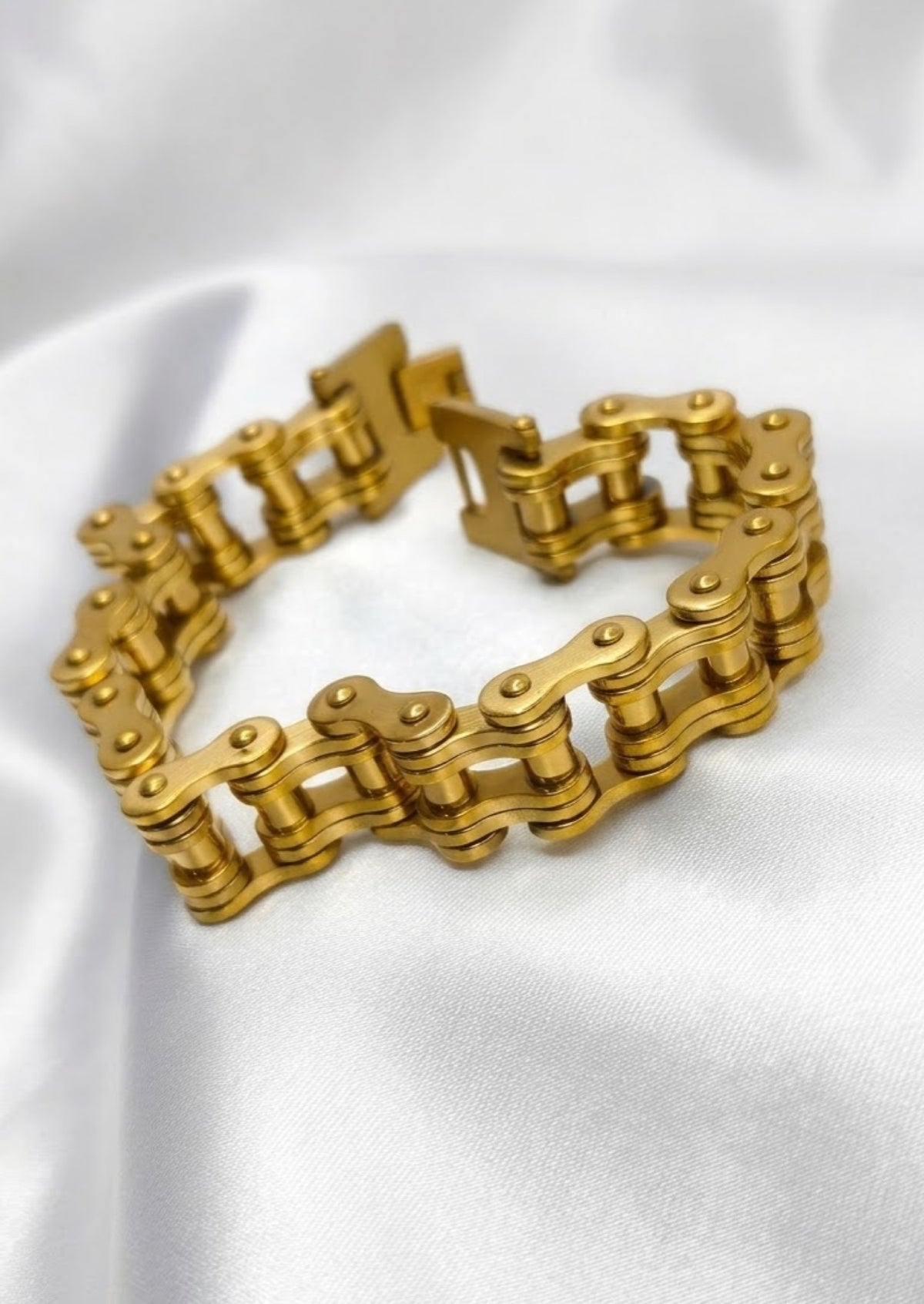 Gold-tone bike chain link bracelet with fold-over clasp on white satin - view 2