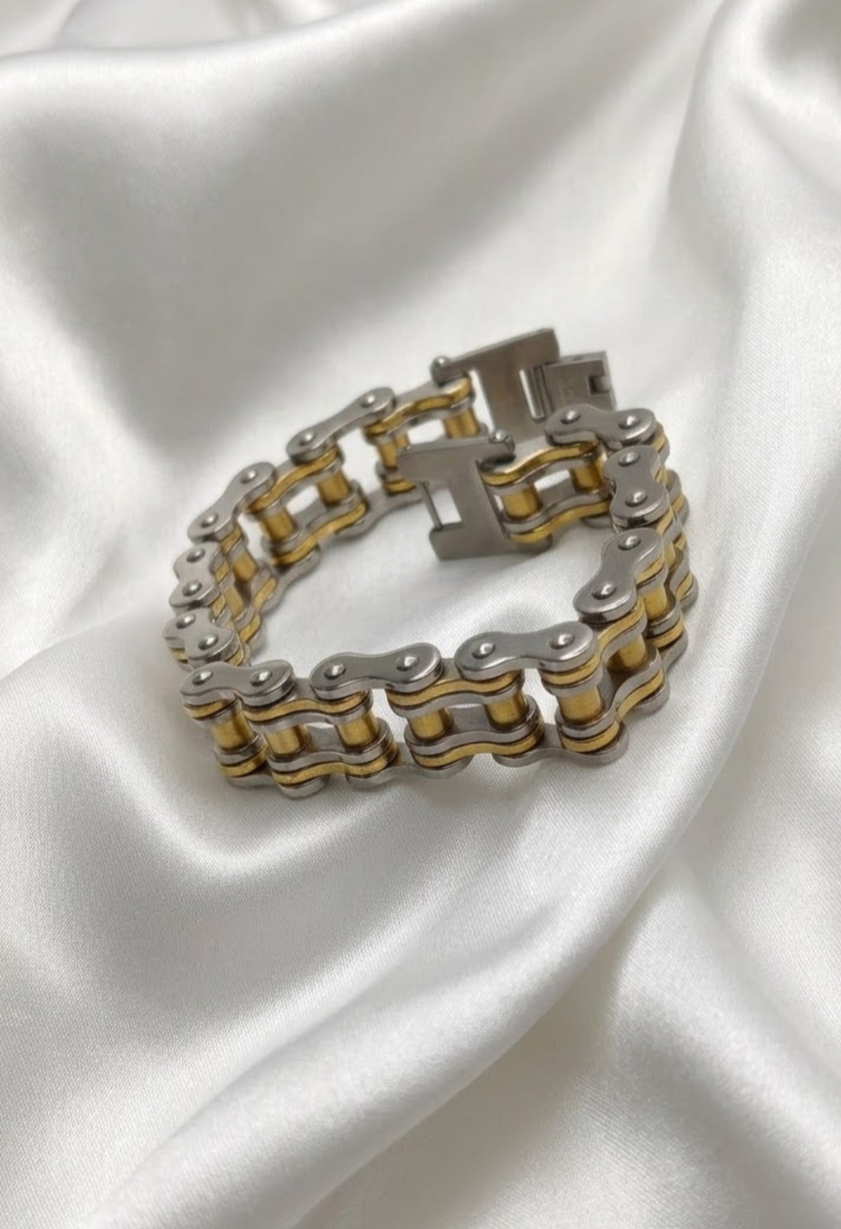 Gold-tone bike chain link bracelet with fold-over clasp on white satin - view 3
