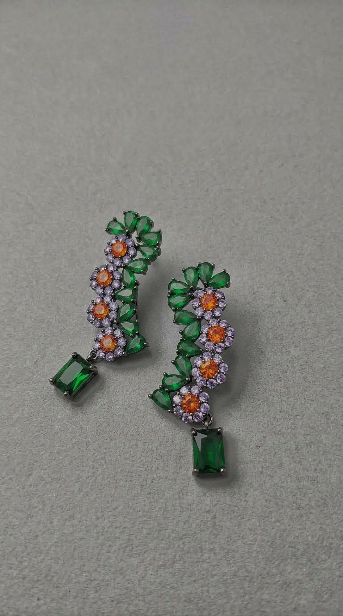 Gunmetal-tone floral ear climbers with green, orange and lavender stones