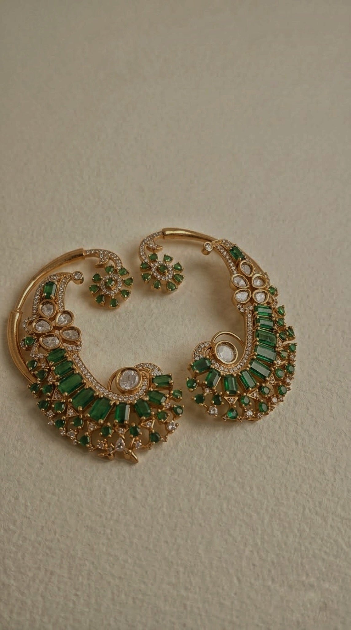 Gold-tone full-ear cuffs with green baguette stones and kundan-look petals