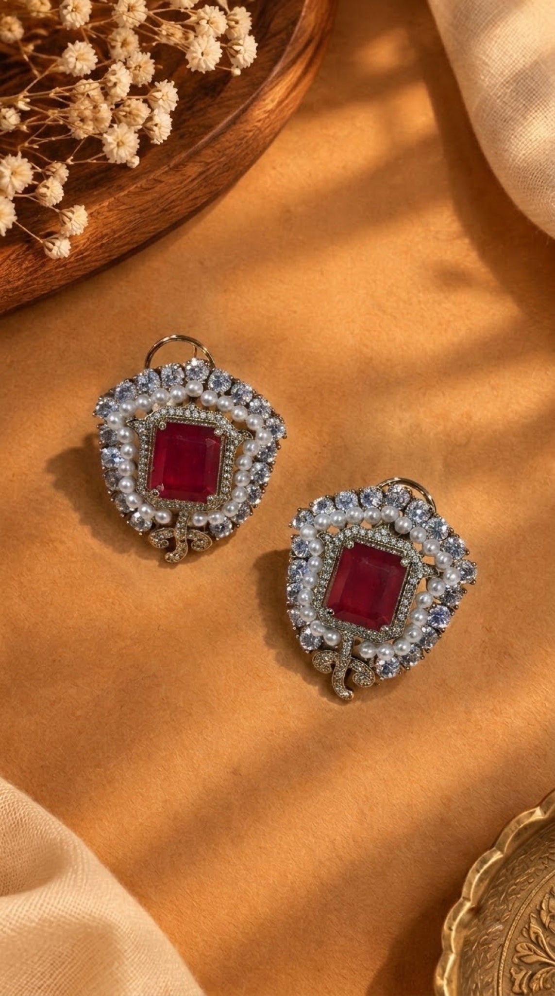 Shield-shaped stud earrings with red stone, faux pearls and crystals