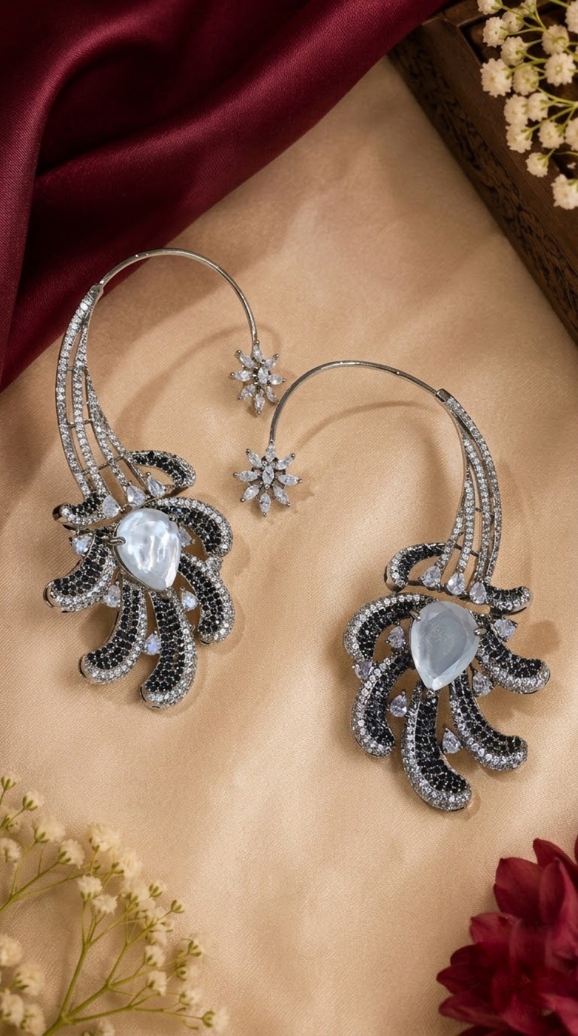 Silver-tone ear cuff earrings with black and clear stone plumes