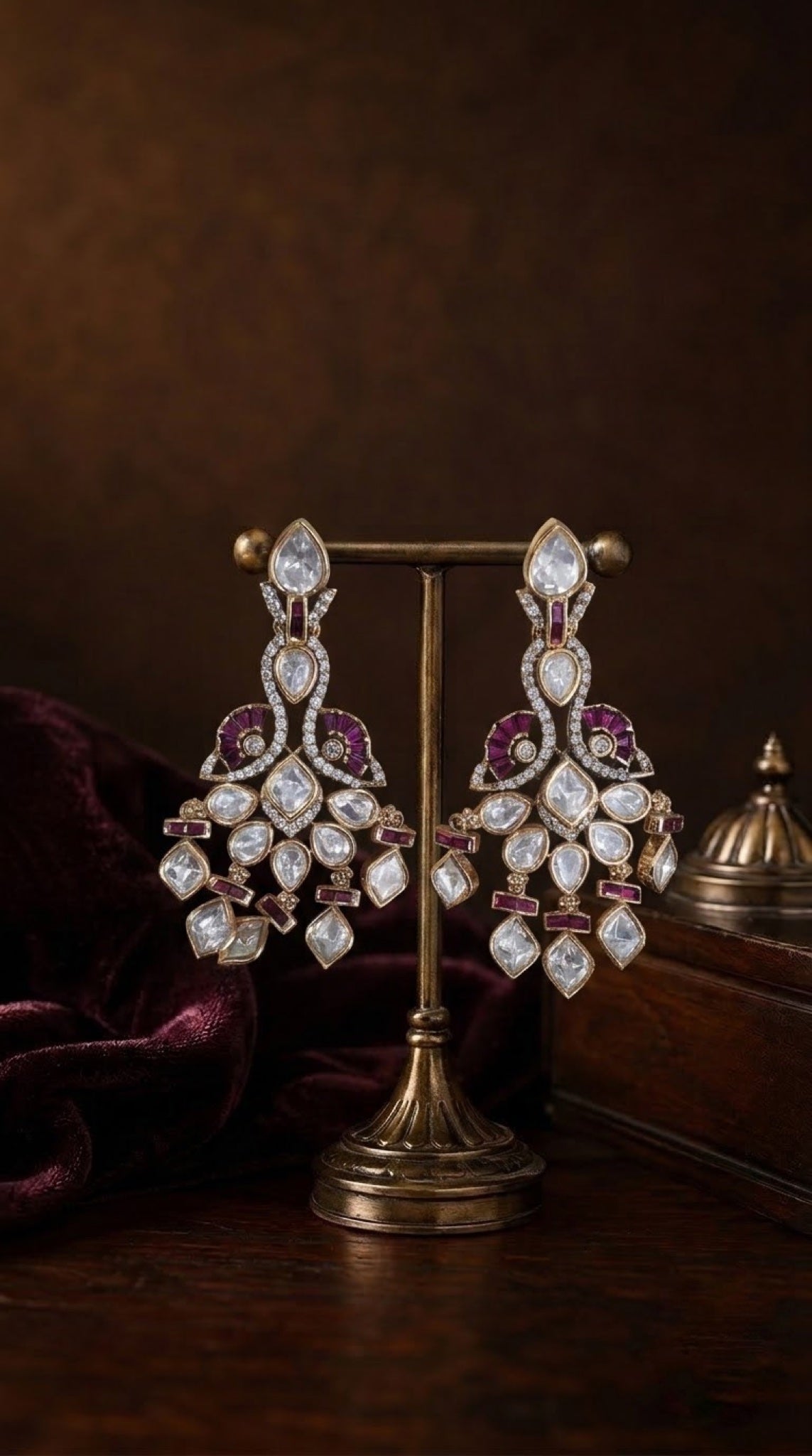 Gold-tone kundan chandelier earrings with ruby-accented peacock motif