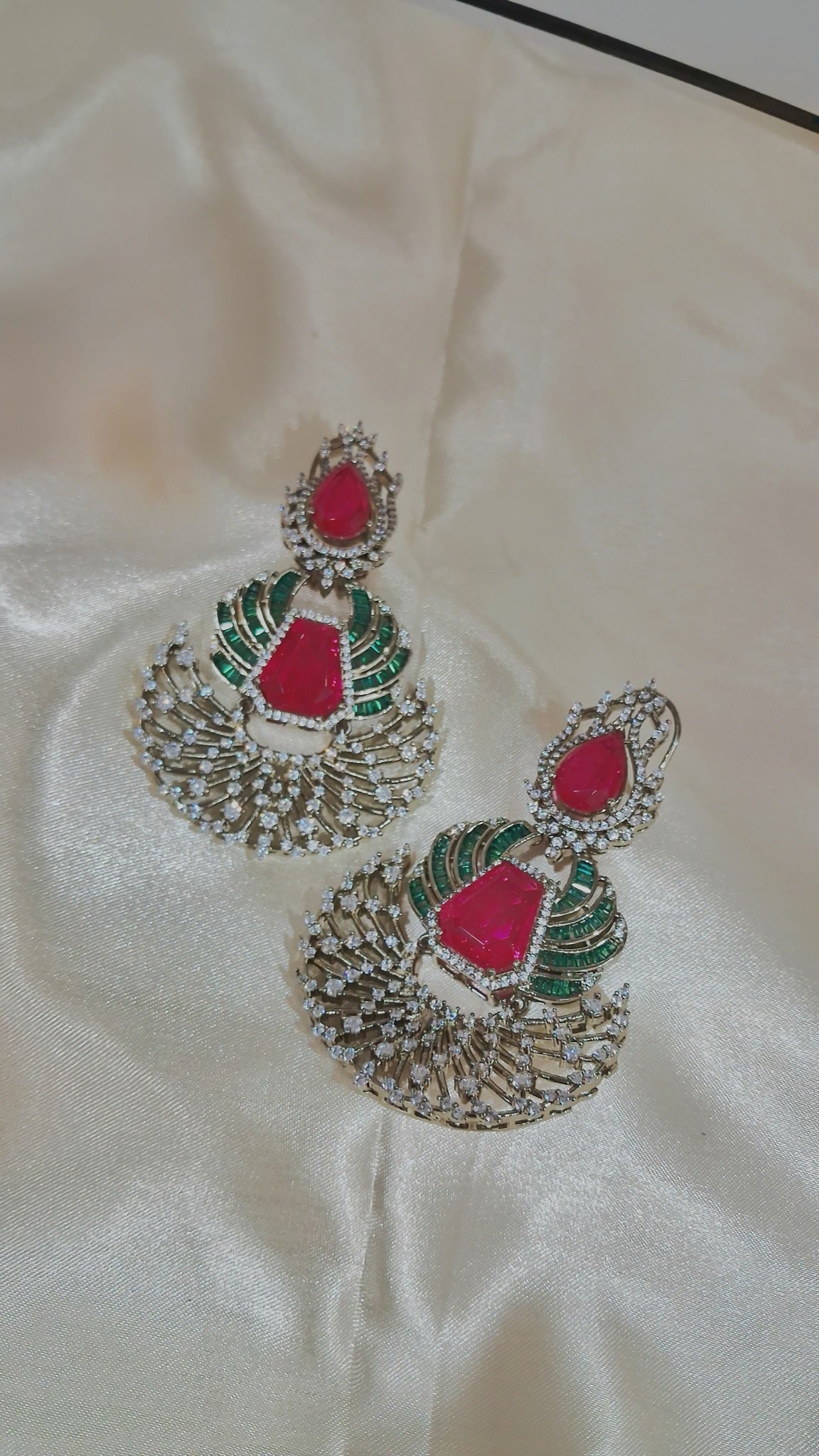 Dual-tone chandbali earrings with red stones, green baguettes and CZ fan