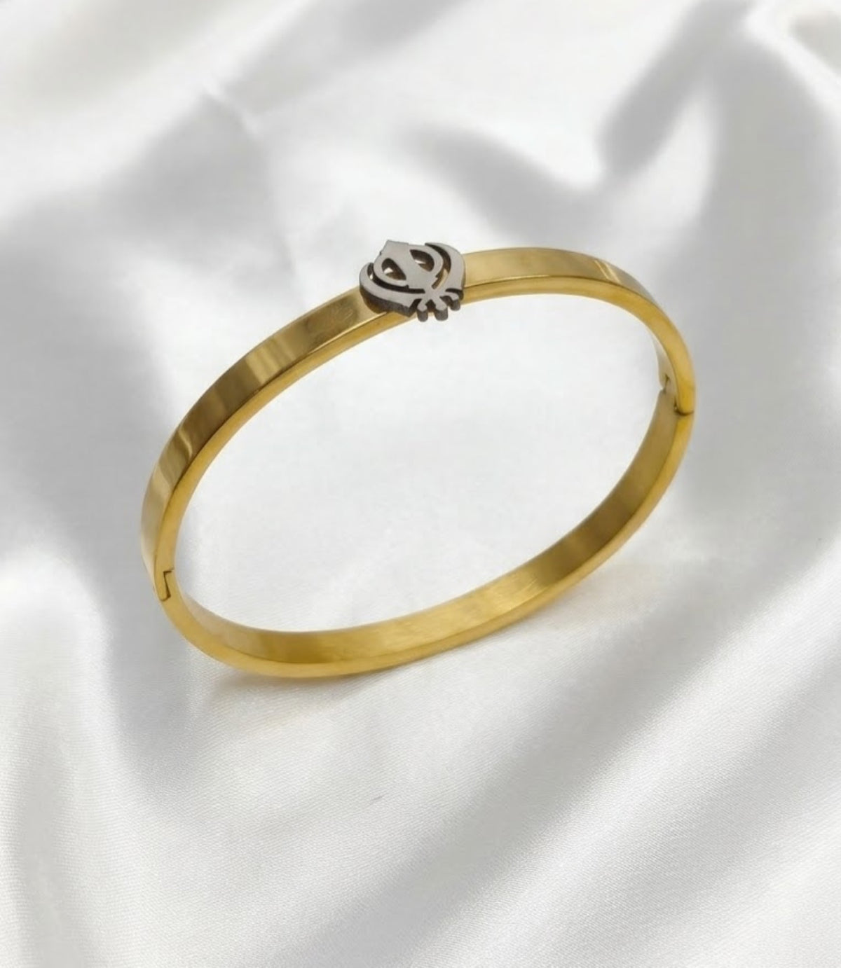 Gold-tone kada bracelet with raised silver-tone Sikh Khanda emblem