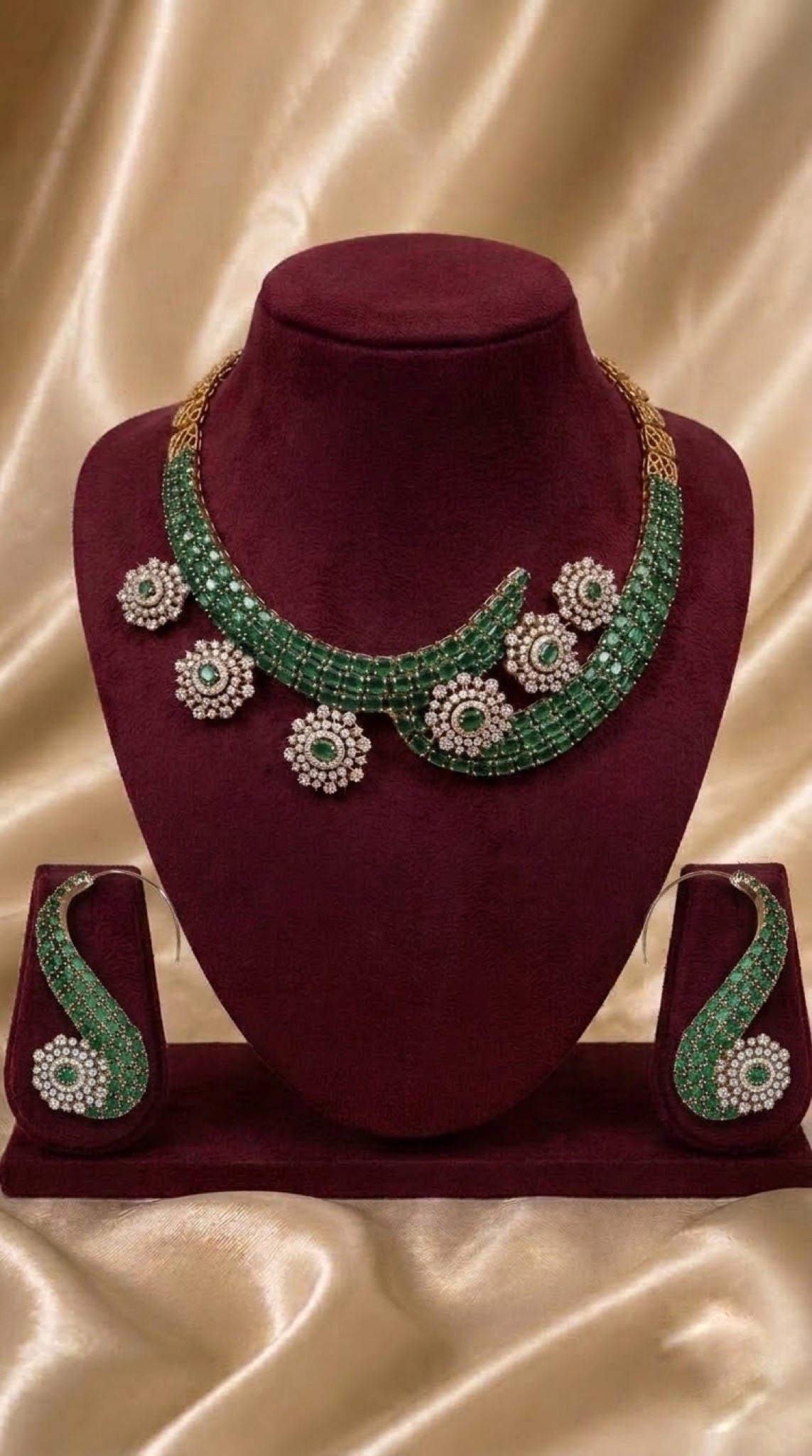 Gold-tone curved necklace set with emerald-green stones and crystal rosettes