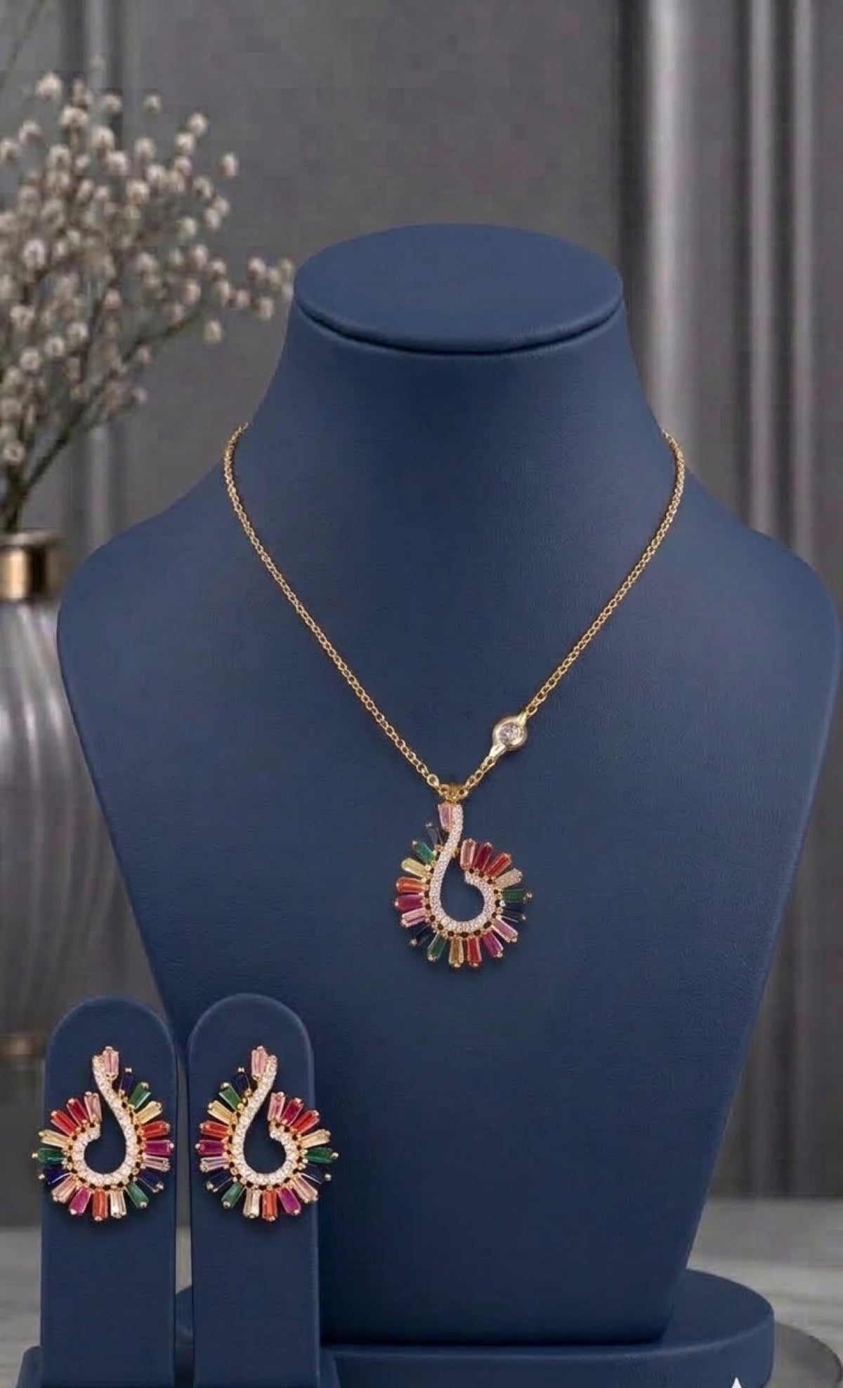 Gold-tone swirl pendant set with rainbow baguette stones