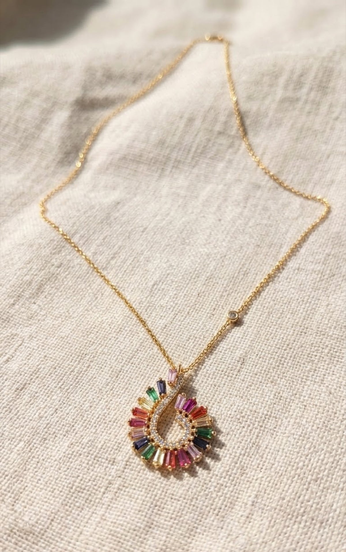Gold-tone swirl pendant set with rainbow baguette stones - view 3