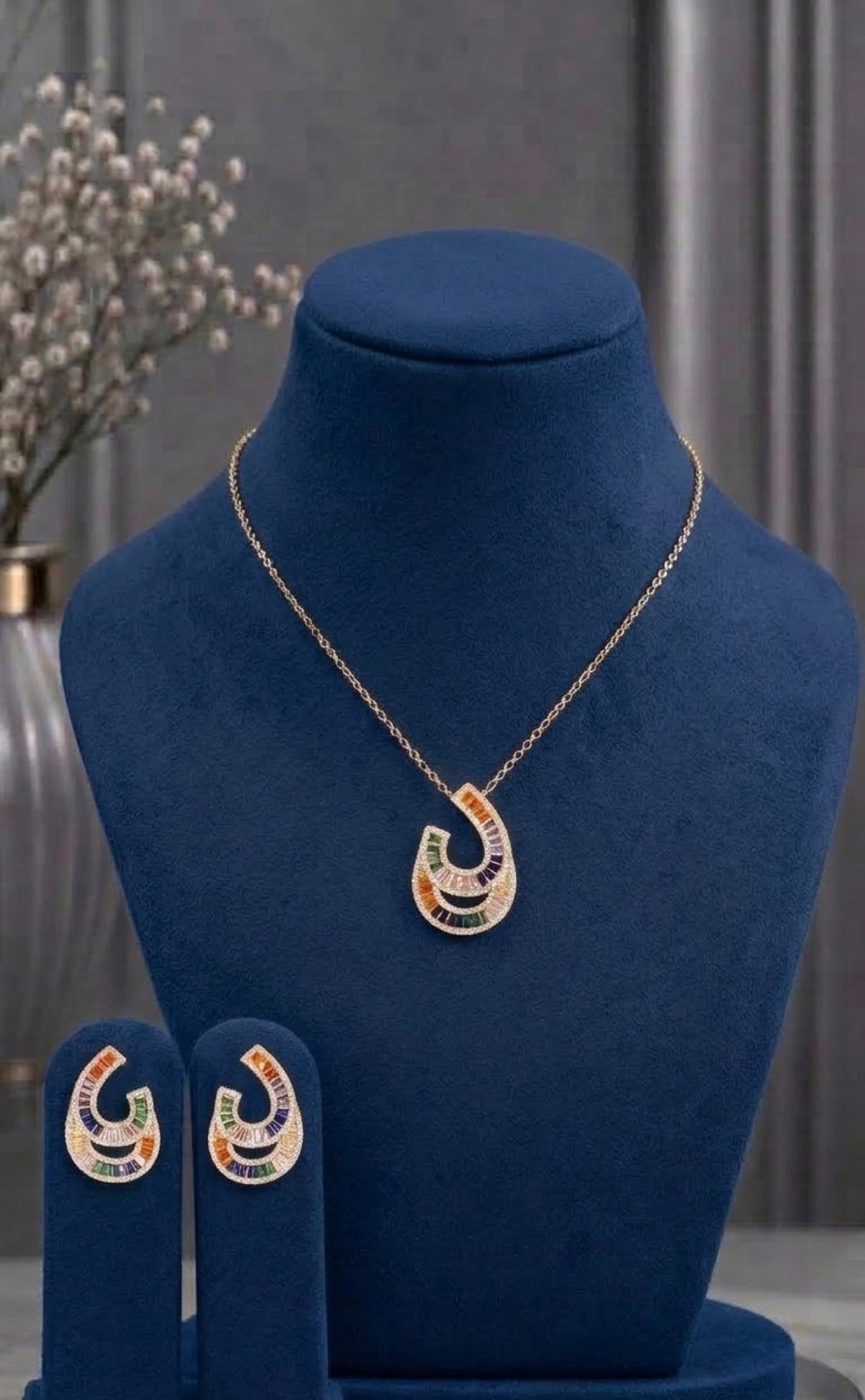 Gold-tone crescent loop pendant set with multicoloured baguettes