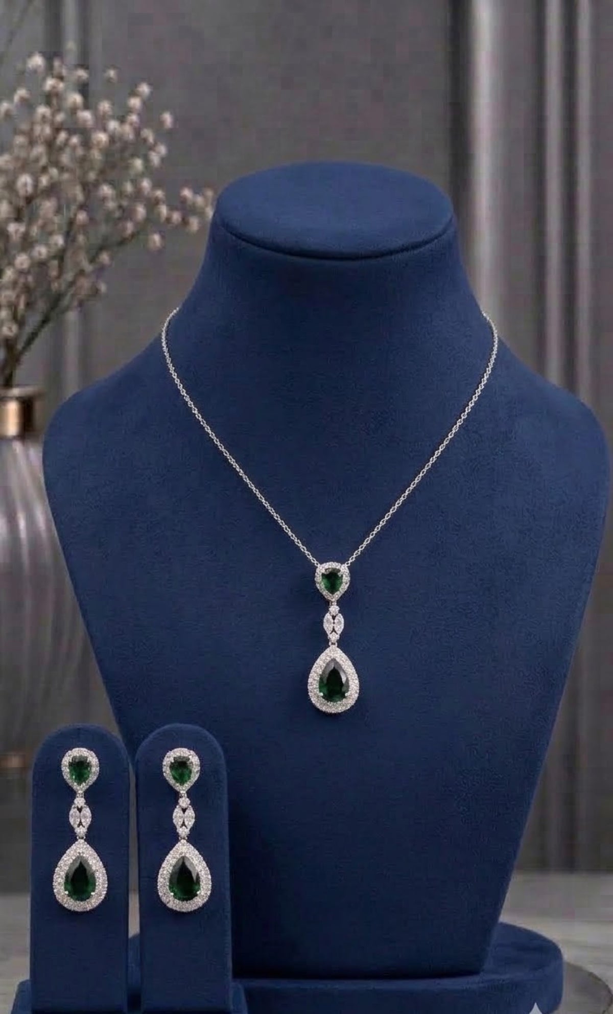 Silver-tone pendant set with emerald-green teardrops and crystal halos
