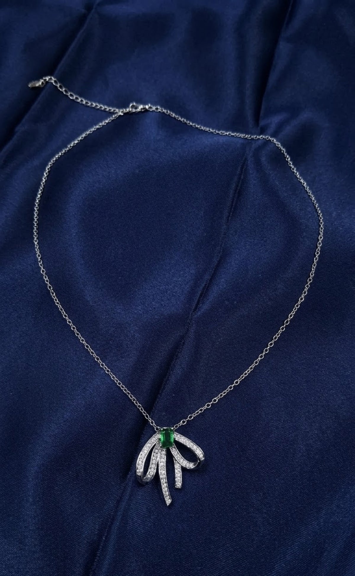 Silver-tone ribbon bow pendant set with green stone